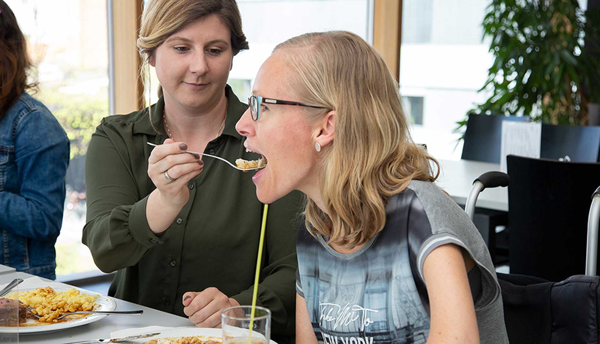 Assistentin unterstützt Assistenznehmerin beim Essen